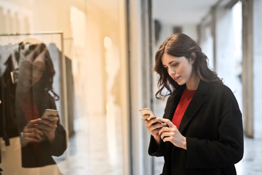 junge Frau blickt auf ihr Smartphone Mode-Influencer werden Lohnt sich das